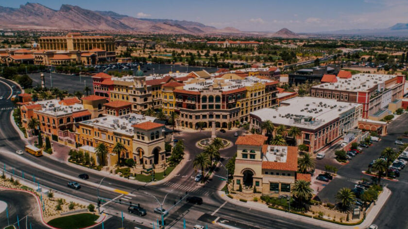 Aerial view of Tivoli Village in Las Vegas surrounded by desert mountains and city roads